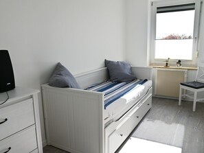 A bedroom with a bed, a desk, and a chair. - Beach paws: Dogs welcome - and the whole family too (Fehmarn)