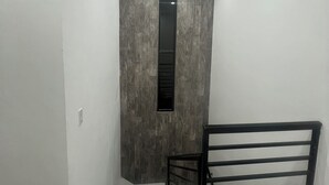 A narrow hallway with a modern design, featuring a textured wall, a black-framed window, and a metal railing. - Welcoming 3-bedroom house with AC and pool in Puerto Penasco (Puerto peñasco)