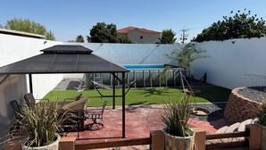 A patio area with a covered seating area, a pool, and a small garden. - Welcoming 3-bedroom house with AC and pool in Puerto Penasco (Puerto peñasco)
