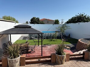 A patio area with a covered seating area, a pool, and a small garden. - Welcoming 3-bedroom house with AC and pool in Puerto Penasco (Puerto peñasco)