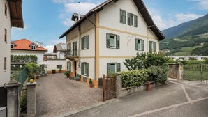 Ein zweistöckiges Haus mit befestigter Auffahrt, einem verschlossenen Eingang und Blick auf ein grünes Tal.