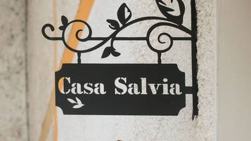 Un panneau noir avec l’inscription « Casa Salvia » et des éléments décoratifs.