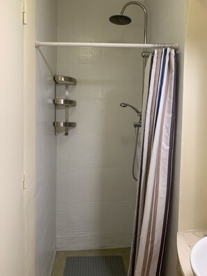A shower area with a white tiled wall, a showerhead, a handheld showerhead, a towel rack, and a striped shower curtain. - FLH Bairro Alto Central Flat with Pateo (Lisboa ciudad)