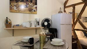 A compact kitchen with a glass table, white appliances, and a fan. - FLH Bairro Alto Central Flat with Pateo (Lisboa ciudad)