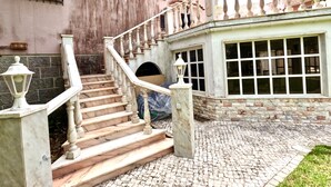 A grand staircase with marble steps and balustrades leading to a building with large windows and a tiled entrance. - FLH Yucca House Carcavelos Beach (Cascais)