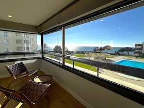 A balcony with a view of a swimming pool and a coastal landscape. - FLH Luxury Atrium Apartment in Cascais with Ocean Views (Cascais)