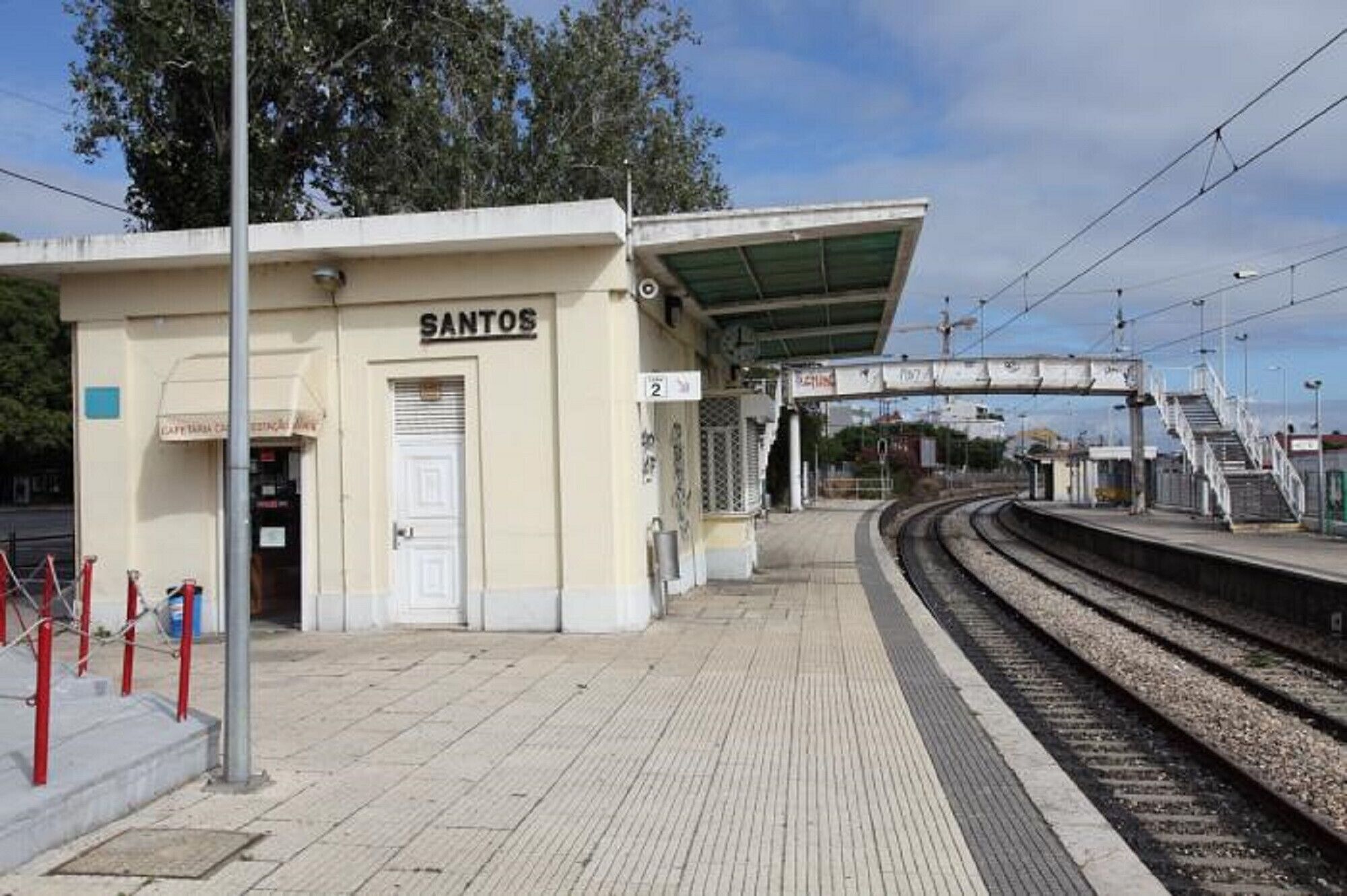 Plataforma de estação de trem com um edifício identificado como 