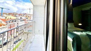 A balcony with a view of a cityscape, including buildings and construction cranes. - FLH Santos Elegant Studio (Lisboa ciudad)