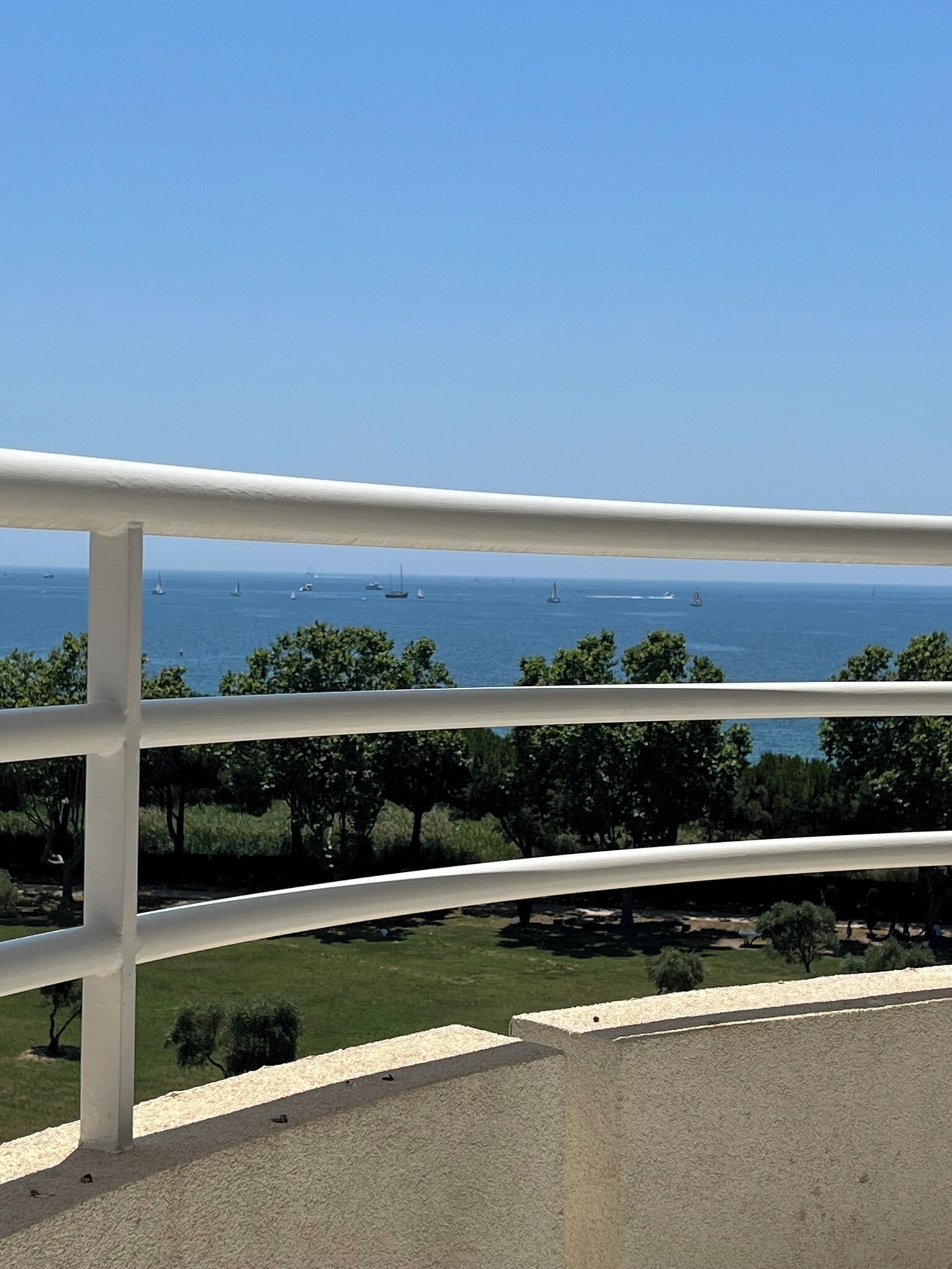 Ein Balkon mit Blick auf das Meer und Segelboote.