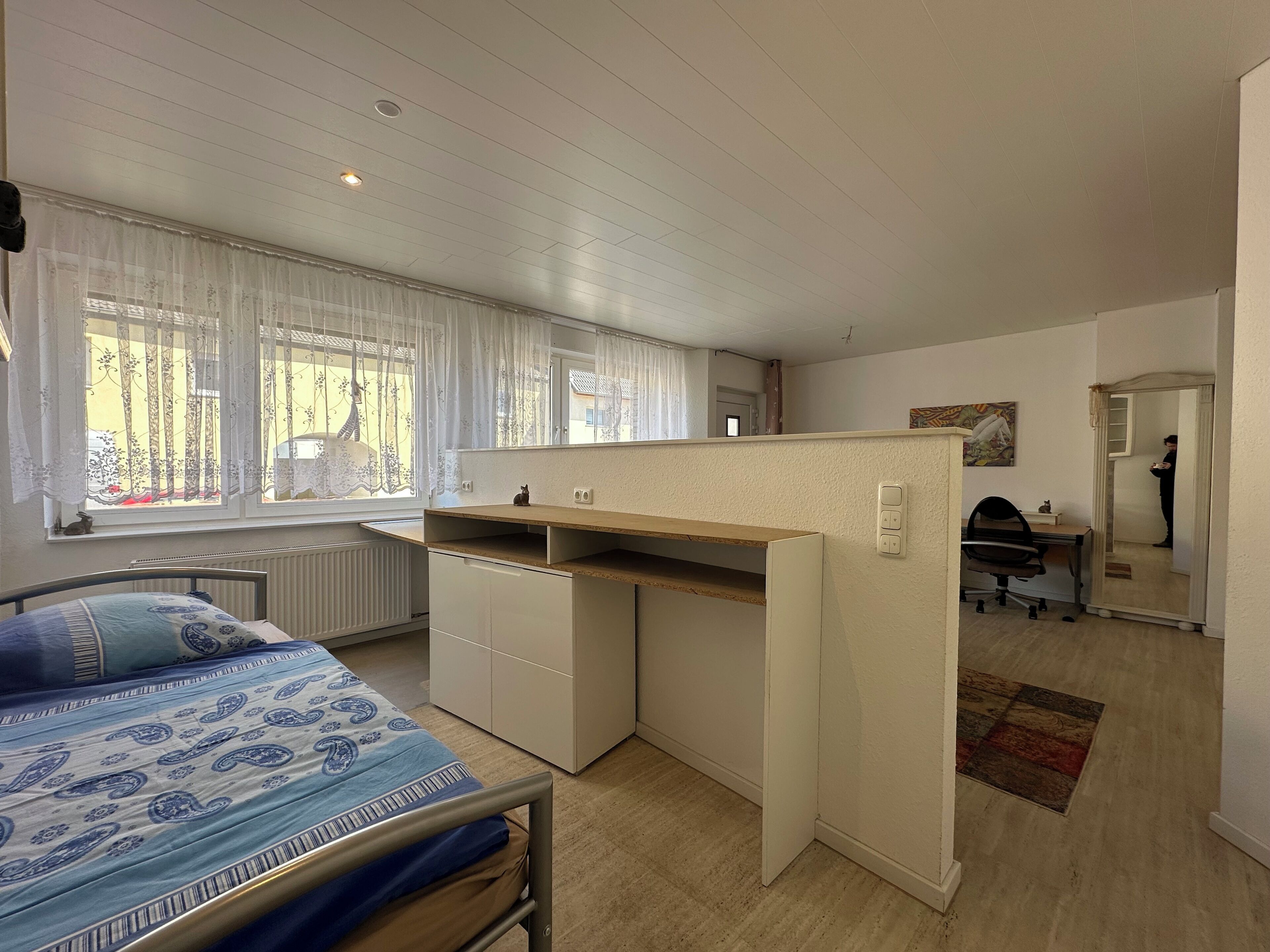 Ein Schlafzimmer mit einem Bett, einem Schreibtisch und einem Stuhl.