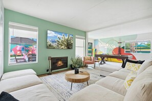 A living room with a fireplace, a sofa, a coffee table, and a painting on the wall. - Basketball, Pickleball, Golf, Heated Pool, Hot Tub (Scottsdale)