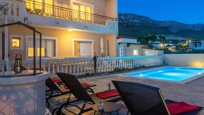 A hotel with a pool, outdoor seating, and a view of the mountains. - Dare Apartment with private pool and garden (Kaštel Sućurac)