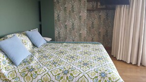 A bedroom with a bed, a television mounted on the wall, and a window with curtains. - Loft in Quito with the best view and location !!! (Quito)