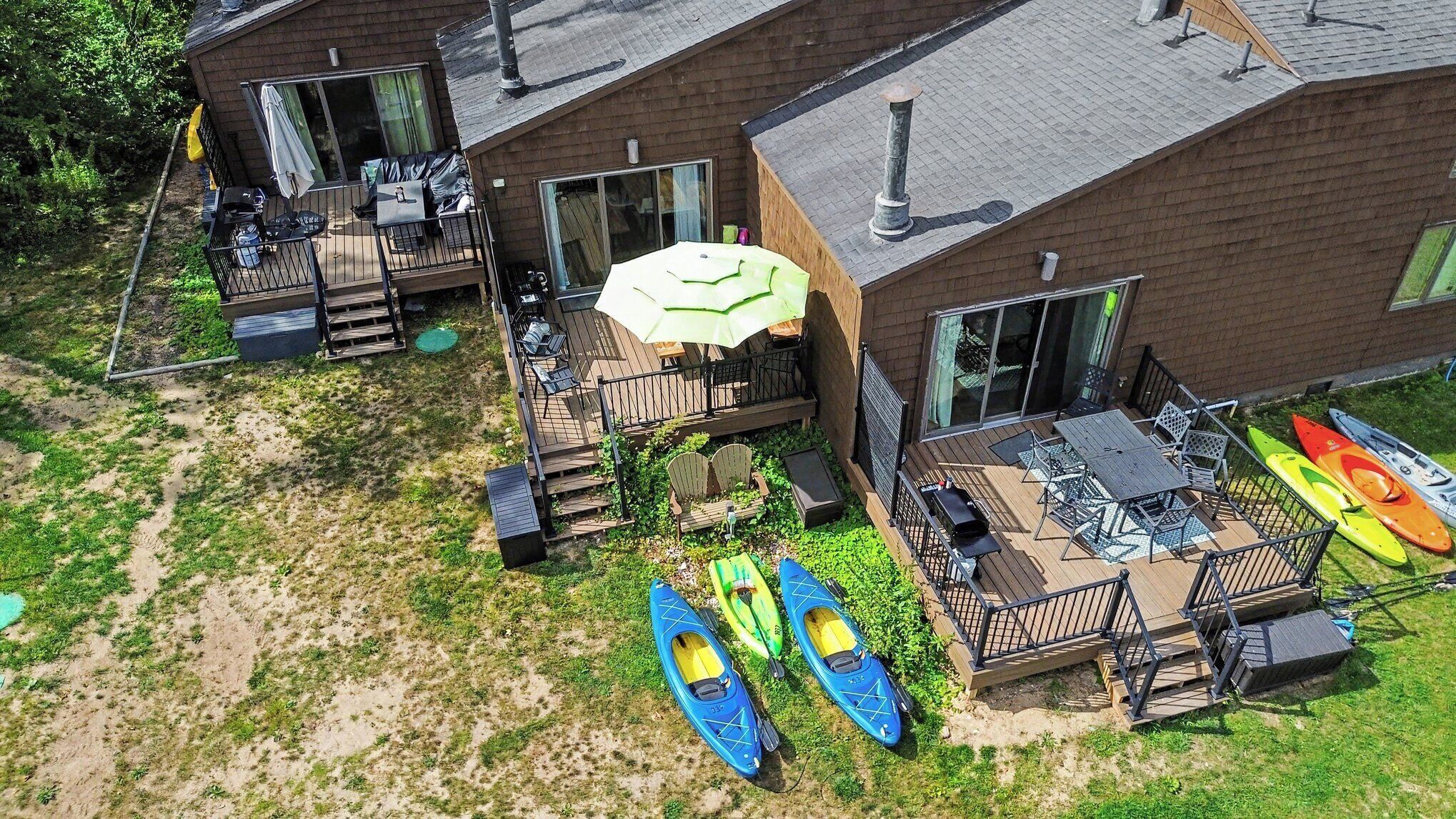 A residential property with a deck, outdoor seating, and kayaks.