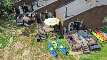 A residential property with a deck, outdoor seating, and kayaks.