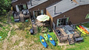 A residential property with a deck, outdoor seating, and kayaks.
