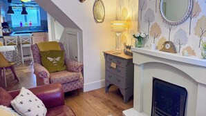 A living room with a sofa, armchairs, a fireplace, and a patterned wallpaper. - Central Chester home. Excellent location. Sleeps 4. Pet friendly. (Chester)