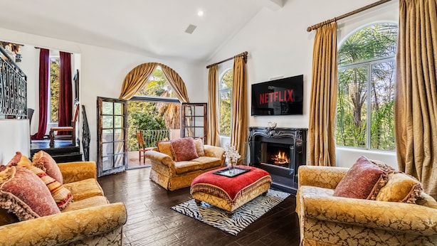 Un salón amplio con chimenea, asientos cómodos y grandes ventanales que ofrecen vistas al exterior.