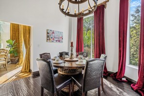 Comedor con una mesa redonda, sillas y una araña.