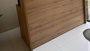 A wooden reception desk with a glass partition, a white wall, and a view of a construction site outside. - Lar dos  Lençoís bhs (Barreirinhas)