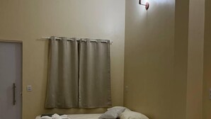 A hotel room with two beds, beige walls, a curtain, and a light fixture. - Lar dos  Lençoís bhs (Barreirinhas)