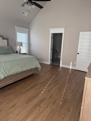 A bedroom with a bed, a ceiling fan, a window with blinds, a door, and a wooden floor. - 2026 Masters Rental - 11 Miles from Augusta National (Evans)