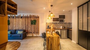Een moderne keuken met een houten eiland, een blauwe bank en een decoratief wandpaneel.