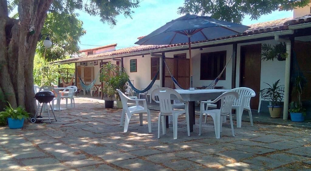 An outdoor patio with a table and chairs, a hammock, and potted plants.