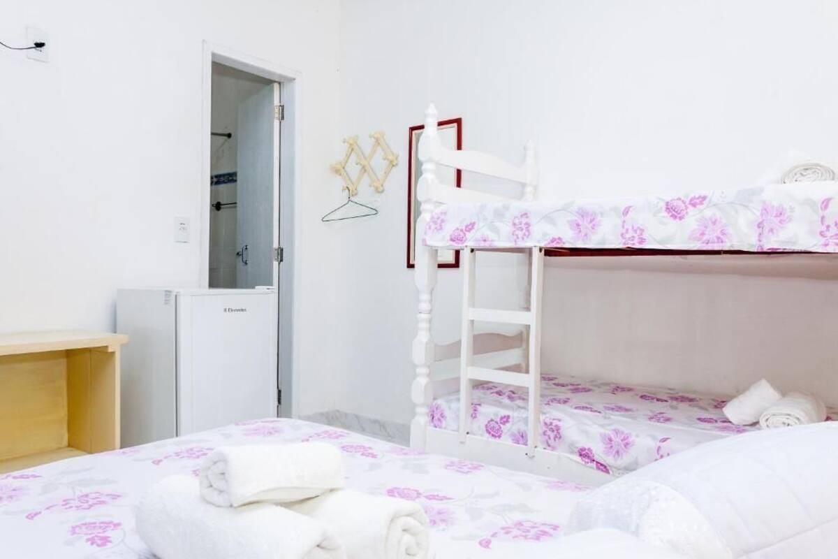 Un dormitorio con dos camas, un armario y un escritorio pequeño.