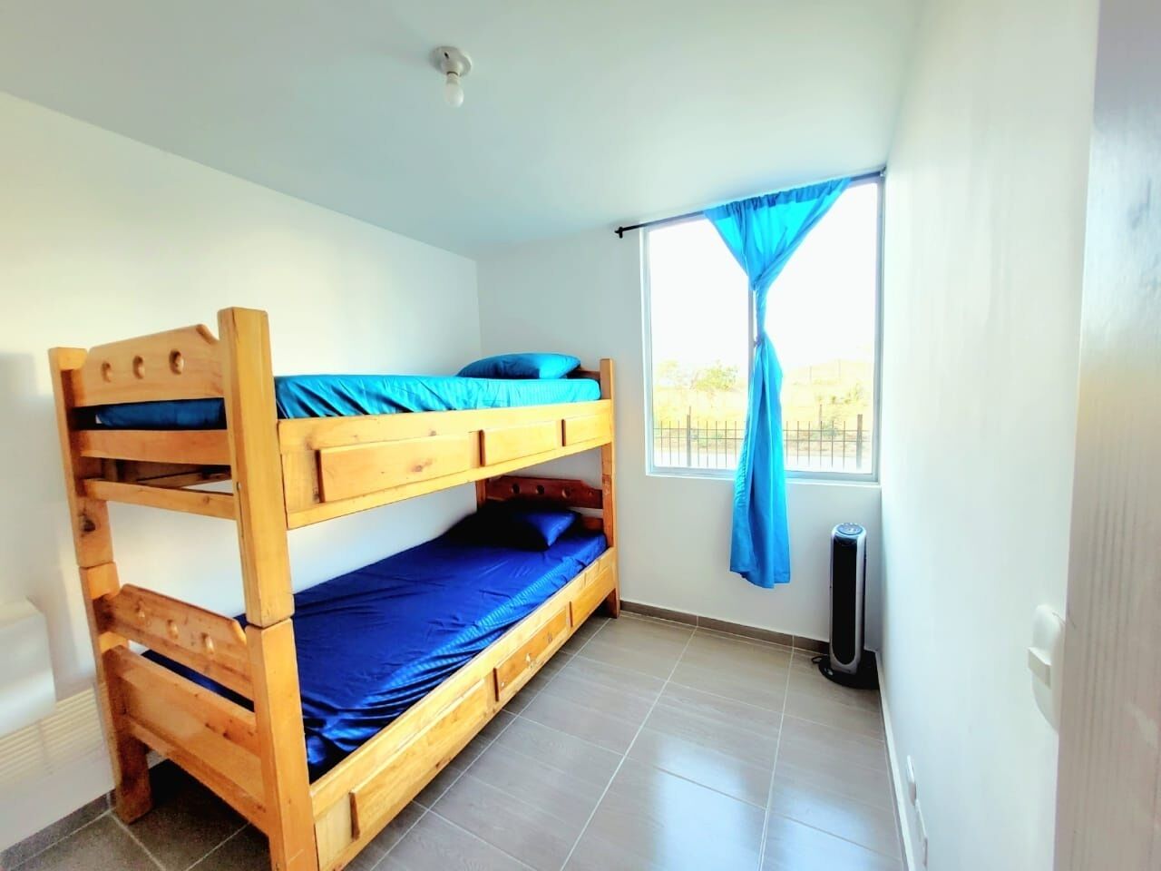 Habitación con literas, ventana y calentador.