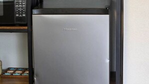 Een Hisense koelkast in een keuken, met een magnetron erboven.