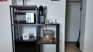 A kitchenette with a coffee maker, a sign reading "YOU'RE KILLIN' ME - SMALLS!", and a book titled "BASEBALL HALL OF FAME". - The Bambino at PWC (Hot Springs)