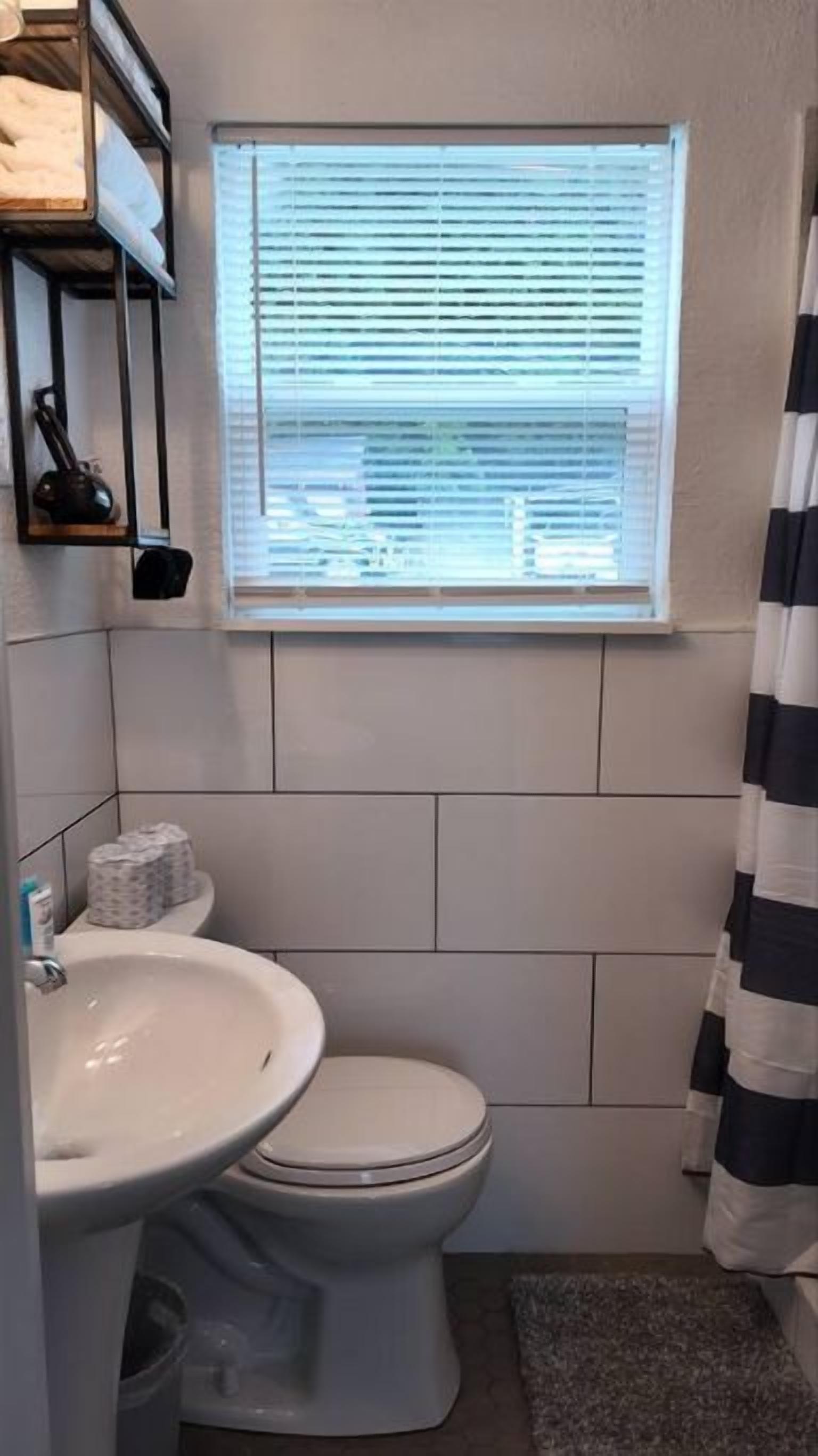 Un bagno piccolo con servizi igienici, lavandino e finestra.
