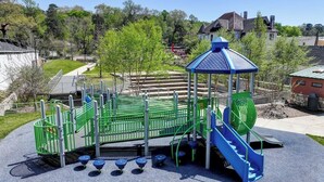 Une aire de jeux avec un toboggan, des structures d’escalade et un espace abrité.
