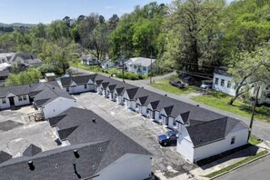A row of single-story houses with sloped roofs, arranged in a linear fashion along a street. - The Ace at PWC (Hot Springs)