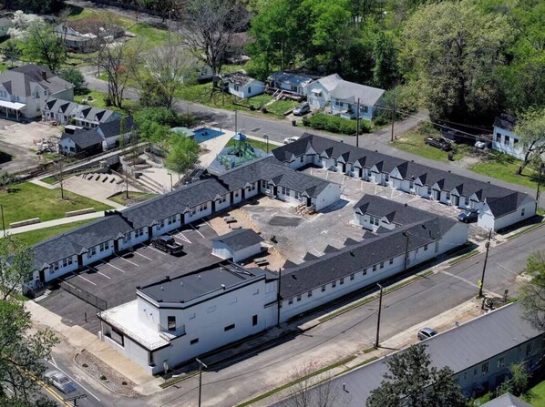 An aerial view of a large industrial building with multiple sections, including a parking lot and a small playground area. - The Ace at PWC (Hot Springs)