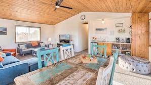 A cozy living room with a wooden ceiling, a sofa, a coffee table, and a television. - Family fun in this spacious 3 bedroom home with game room and ocean views (Brookings)