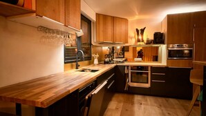 A modern kitchen with wooden cabinets, a built-in oven, and a wooden countertop. - KerSauvage - A peaceful house on Quiberon's Côte Sauvage (Saint-Pierre-Quiberon)