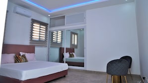 Une chambre à coucher avec un lit, une chaise et un miroir.