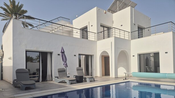 Ein moderner Poolbereich mit Liegestühlen und einem Pool.