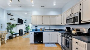 A modern kitchen with white cabinets, a built-in microwave, a stove, and a dishwasher. - Bayfront backyard with a dock, 3BR, Dogs Welcome! (Norfolk)