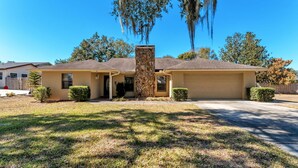 A single-story house with a stone pillar, a garage, and a well-maintained lawn.