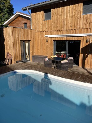 A wooden house with a swimming pool, outdoor furniture, and a covered patio area. - Villa d'Huchet (MOLIETS ET MAA)