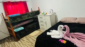 Une chambre à coucher avec un lit, un bureau, une chaise, une armoire et un rideau rouge.