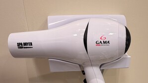 A white spa dryer with the brand GAMA, labeled as a professional Italian model, mounted on a wall with a power outlet below it. - Paradise in Praça 19: 3 min from the village and 5 min from the natural pools! (Ipojuca)