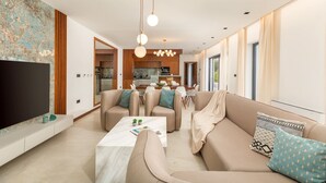 A modern living room with a sofa set, a coffee table, and a flat-screen TV. - Luxurious Villa Istria Green with private pool - for families and nature lovers (Boljevići)