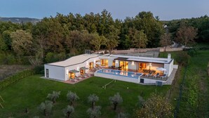 A modern house with a large swimming pool, outdoor seating, and a well-maintained lawn. - Luxurious Villa Istria Green with private pool - for families and nature lovers (Boljevići)