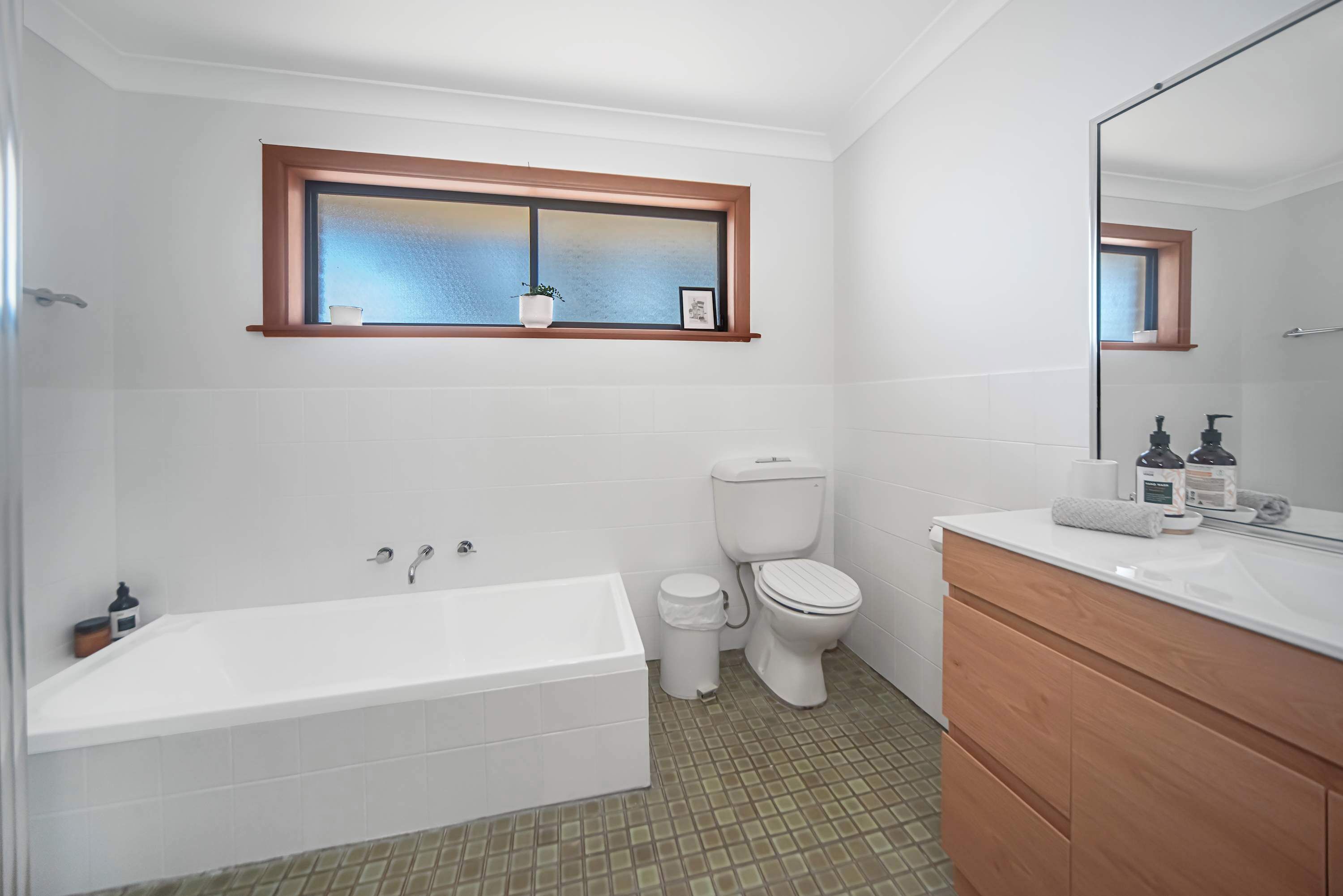 Ein Badezimmer mit Badewanne, Toilette, Waschtisch und einem Fenster mit Blick.