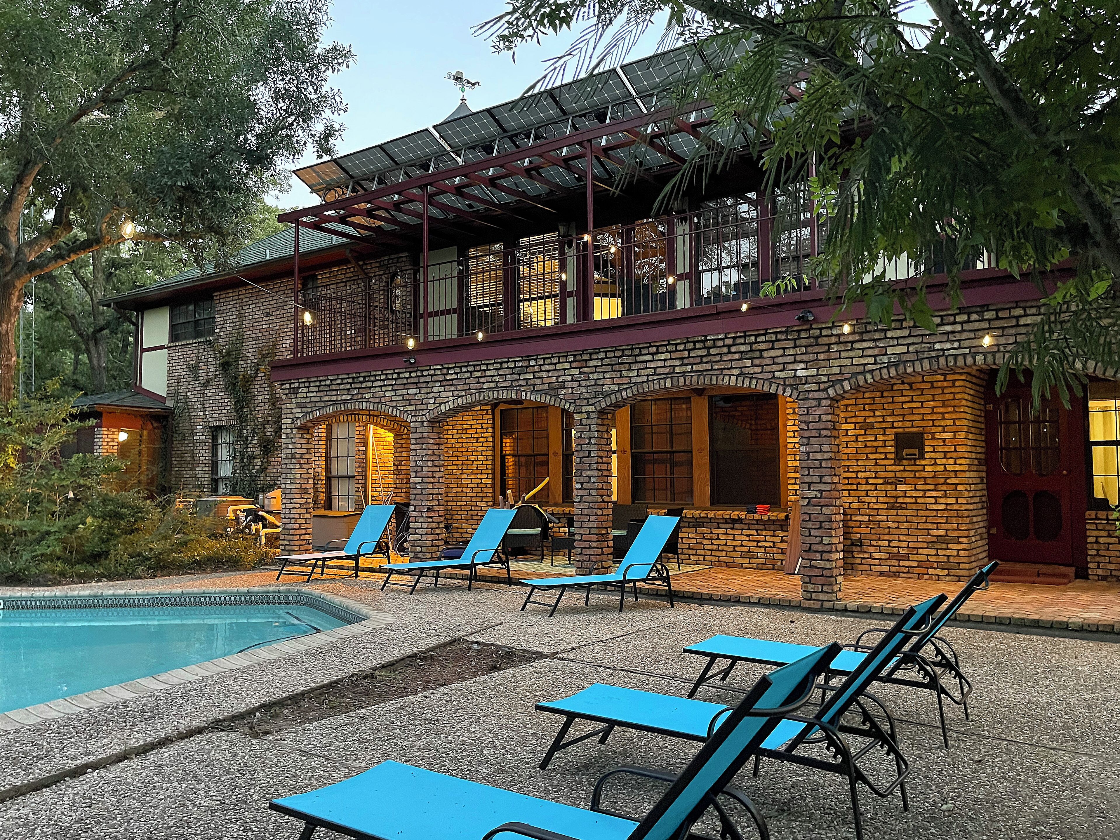 Ein Gebäude mit Pool, Außenbereich zum Sitzen und einer überdachten Terrasse.