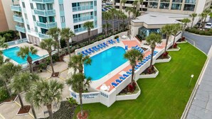 A hotel with a swimming pool surrounded by palm trees and lounge chairs. - Ocean Forest Plaza 2108 (Myrtle Beach)
